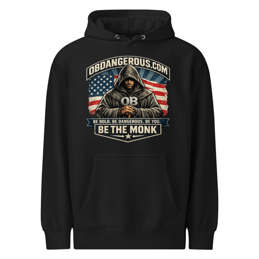 Black unisex Be The Monk premium mid-weight hoodie by OB DANGEROUS, shown from the front, featuring bold graphic design.
